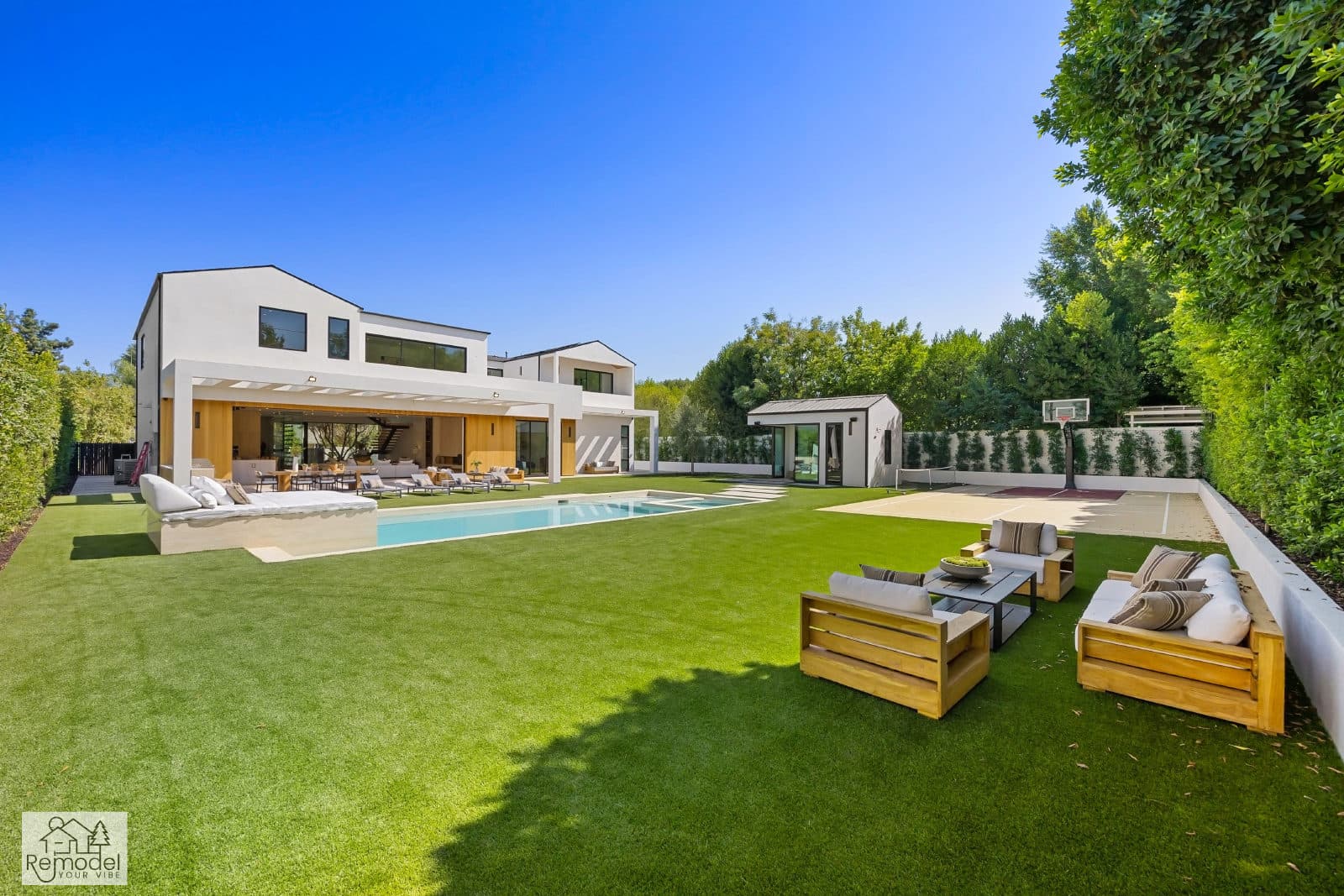 Modern estate backyard with pool, lawn, lounge seating, and sport court, a completed Remodel Your Vibe project